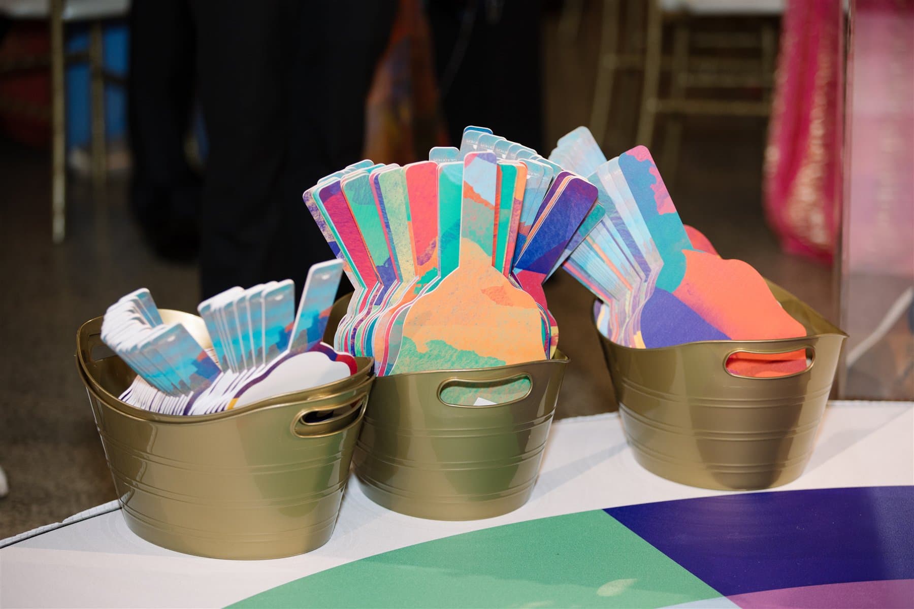 Colorful custom-cut bidder paddles arranged in baskets before the gala auction