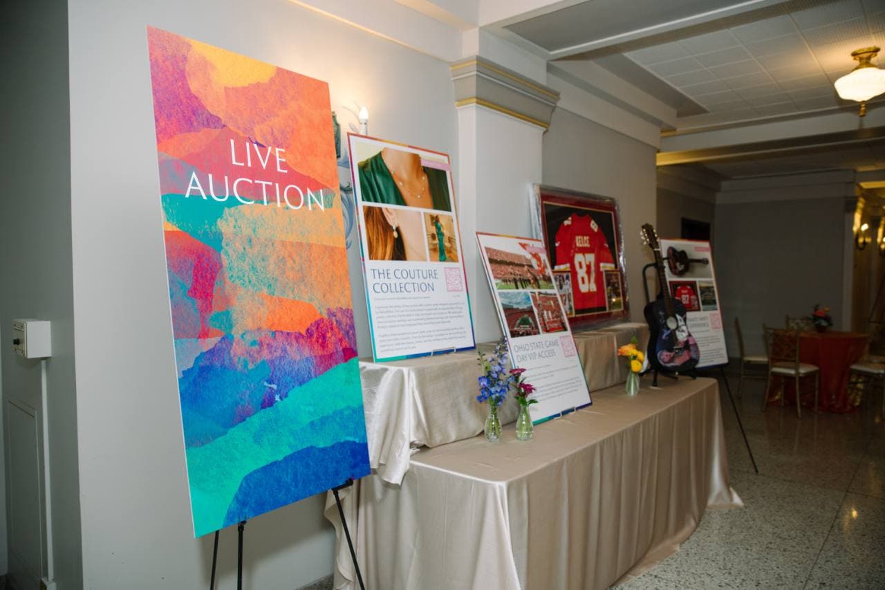 Live auction sign beside printed auction-item display boards