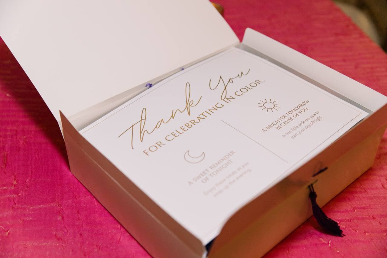 Open gala take-home box showing a gold-lettered thank-you insert