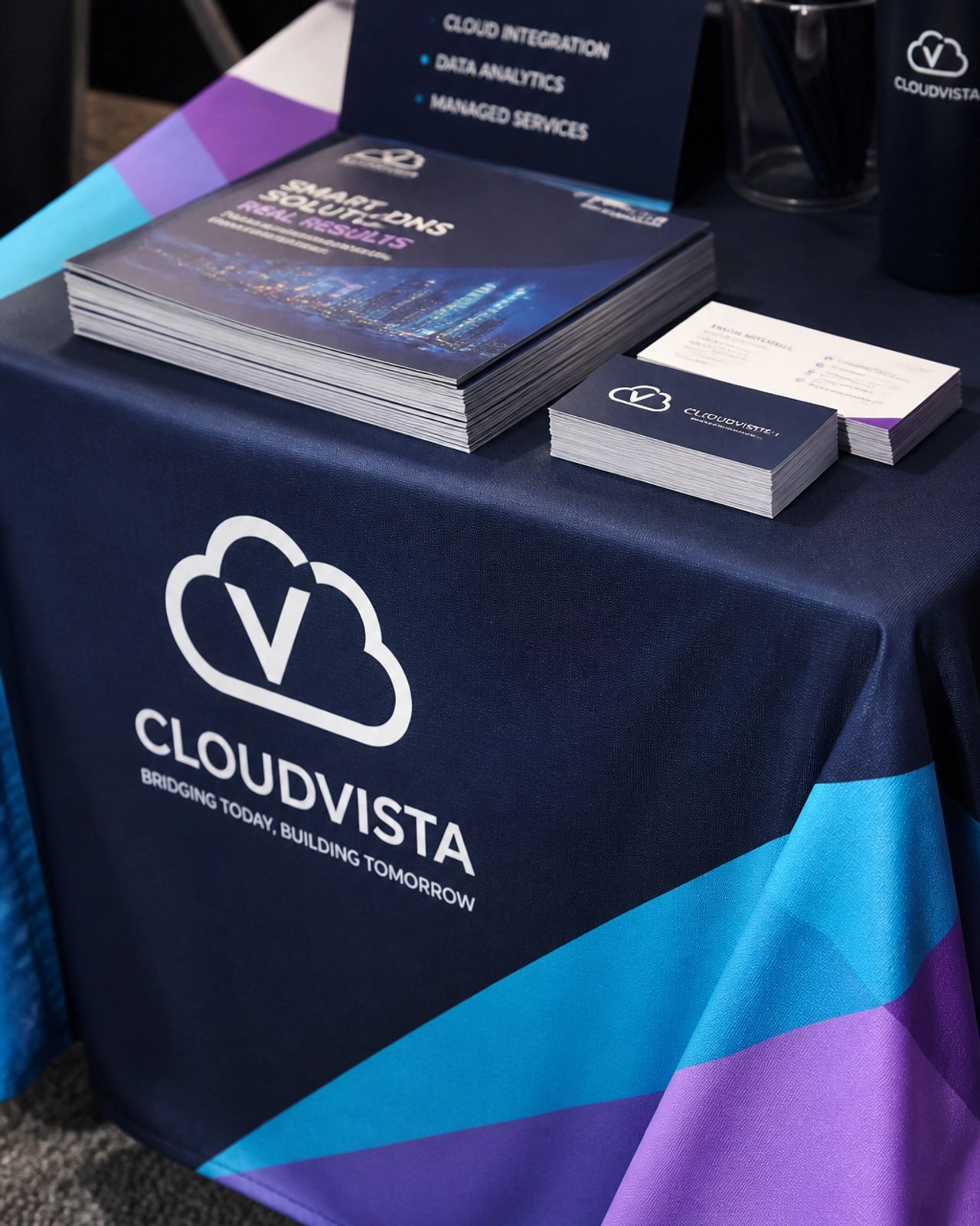 Close-up of a custom-printed table throw with professional marketing booklets and premium business cards.