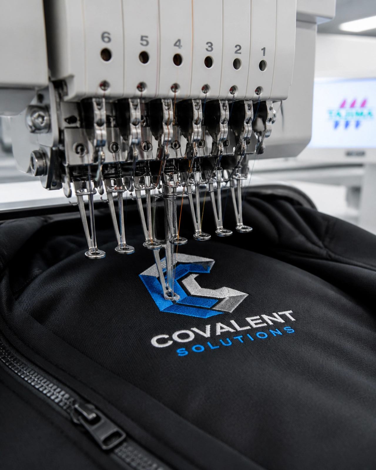 Macro shot of a multi-head embroidery machine stitching a logo